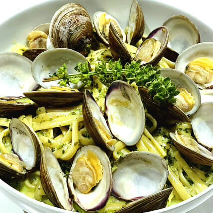 A delectable bowl of pasta adorned with clams and aromatic herbs